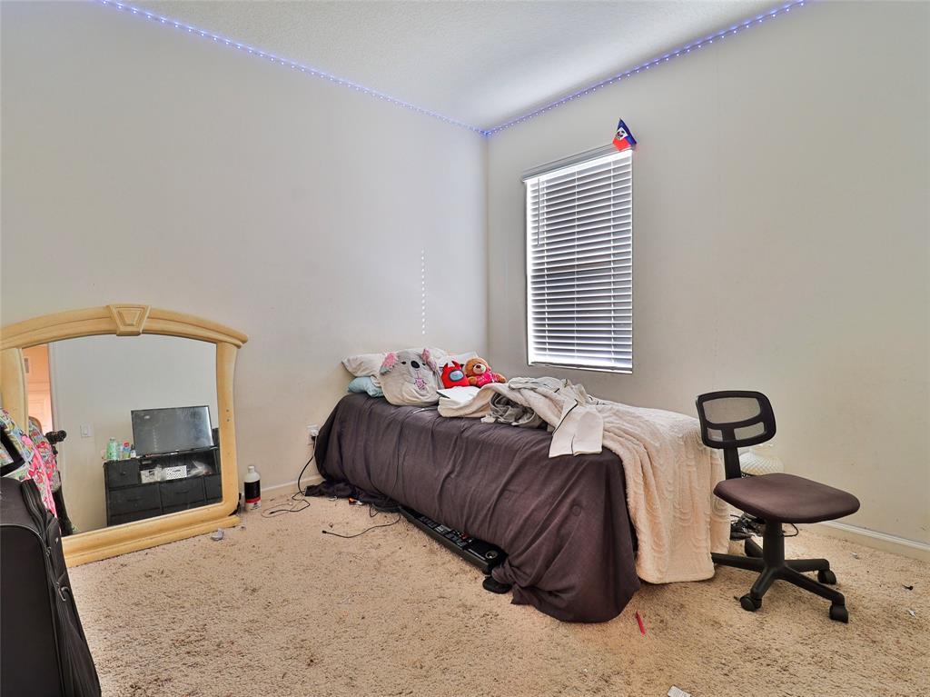 1997 Southwest Cycle Street Port St. Lucie, FL 34953 - Photo 5 of 30 a bedroom with a bed a mirror and a table