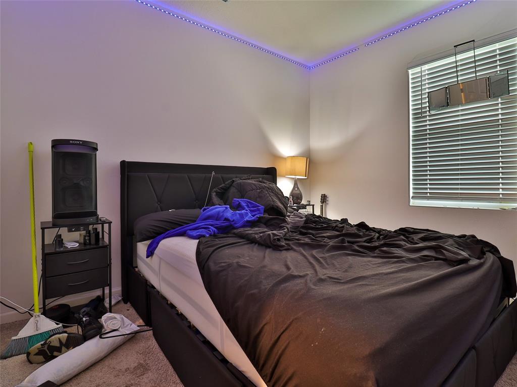 1997 Southwest Cycle Street Port St. Lucie, FL 34953 - Photo 7 of 30 a bed sitting in a bedroom next to a window and tv