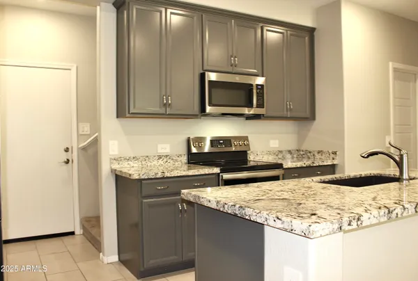 a kitchen with stainless steel appliances granite countertop a sink stove and microwave