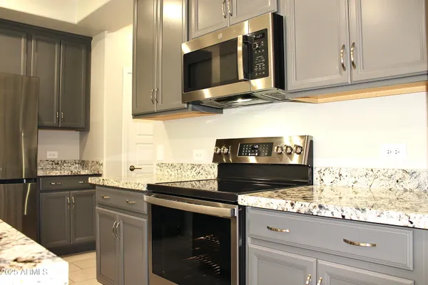 a kitchen with stainless steel appliances granite countertop a stove a sink and a microwave