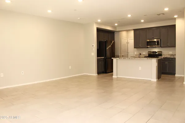 a view of kitchen with stainless steel appliances a refrigerator stove top oven and cabinets