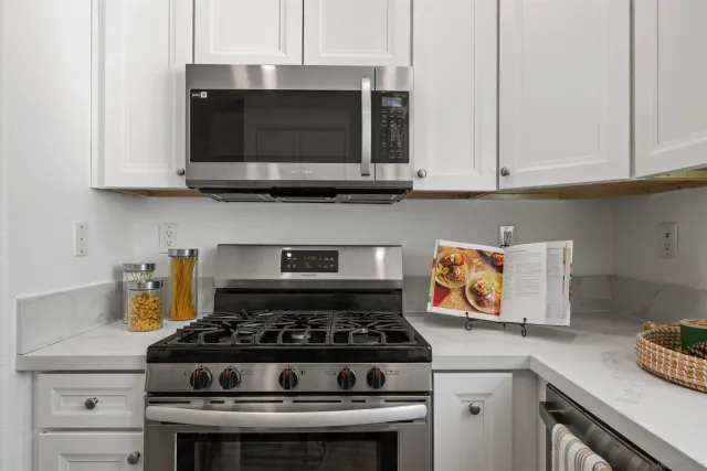 a kitchen with stainless steel appliances granite countertop a stove and a microwave