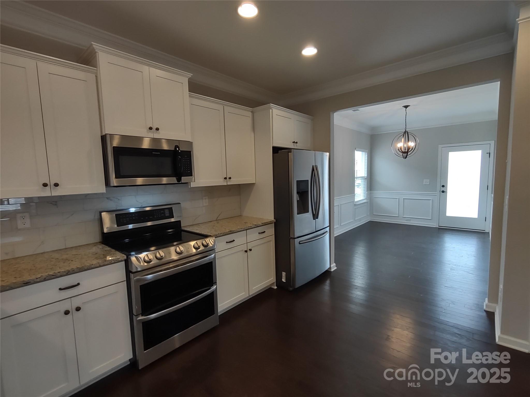 143 Kingston Drive Locust, NC 28097 - Photo 11 of 16 a kitchen with granite countertop a stove a refrigerator and a microwave