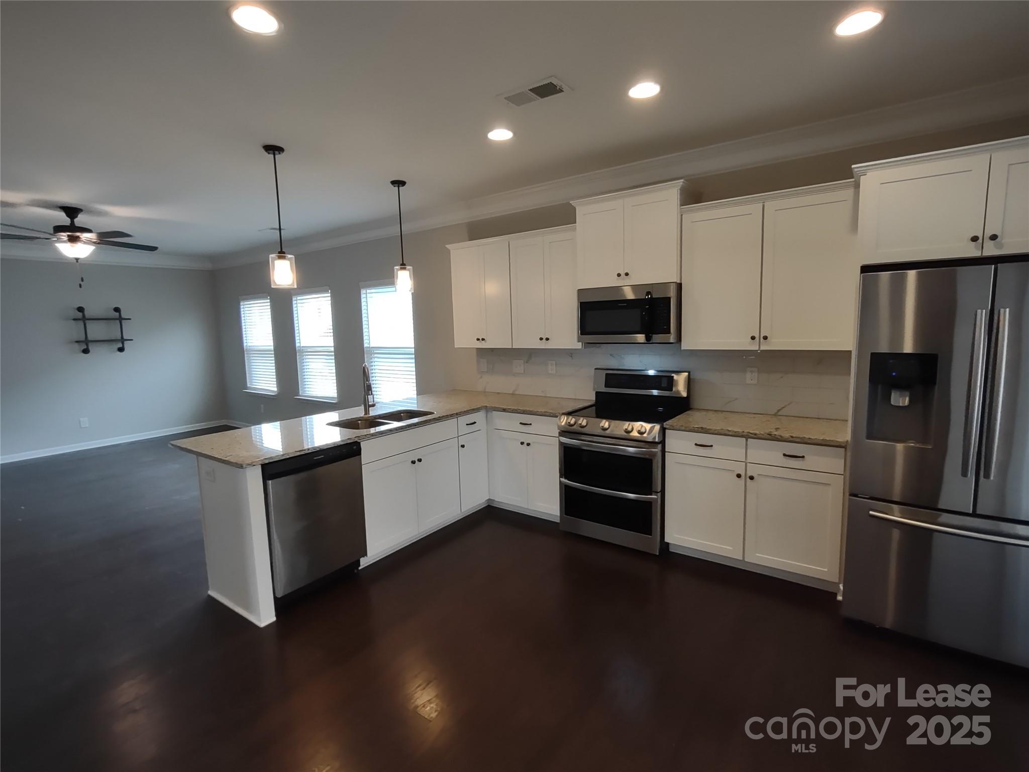 143 Kingston Drive Locust, NC 28097 - Photo 10 of 16 a kitchen with granite countertop a refrigerator stove top oven and sink
