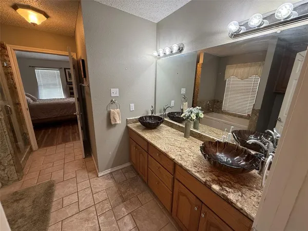 a bathroom with a granite countertop sink a mirror and vanity