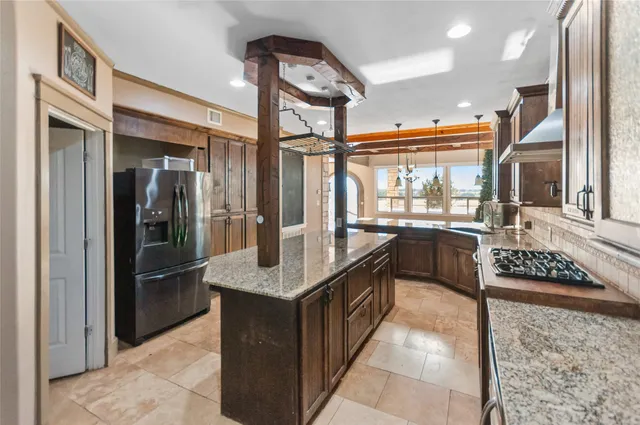 a kitchen with stainless steel appliances granite countertop a refrigerator and a stove