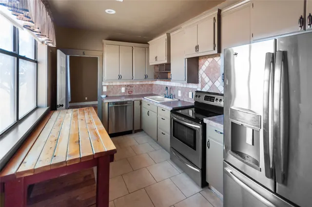 a kitchen with stainless steel appliances a sink stove and refrigerator