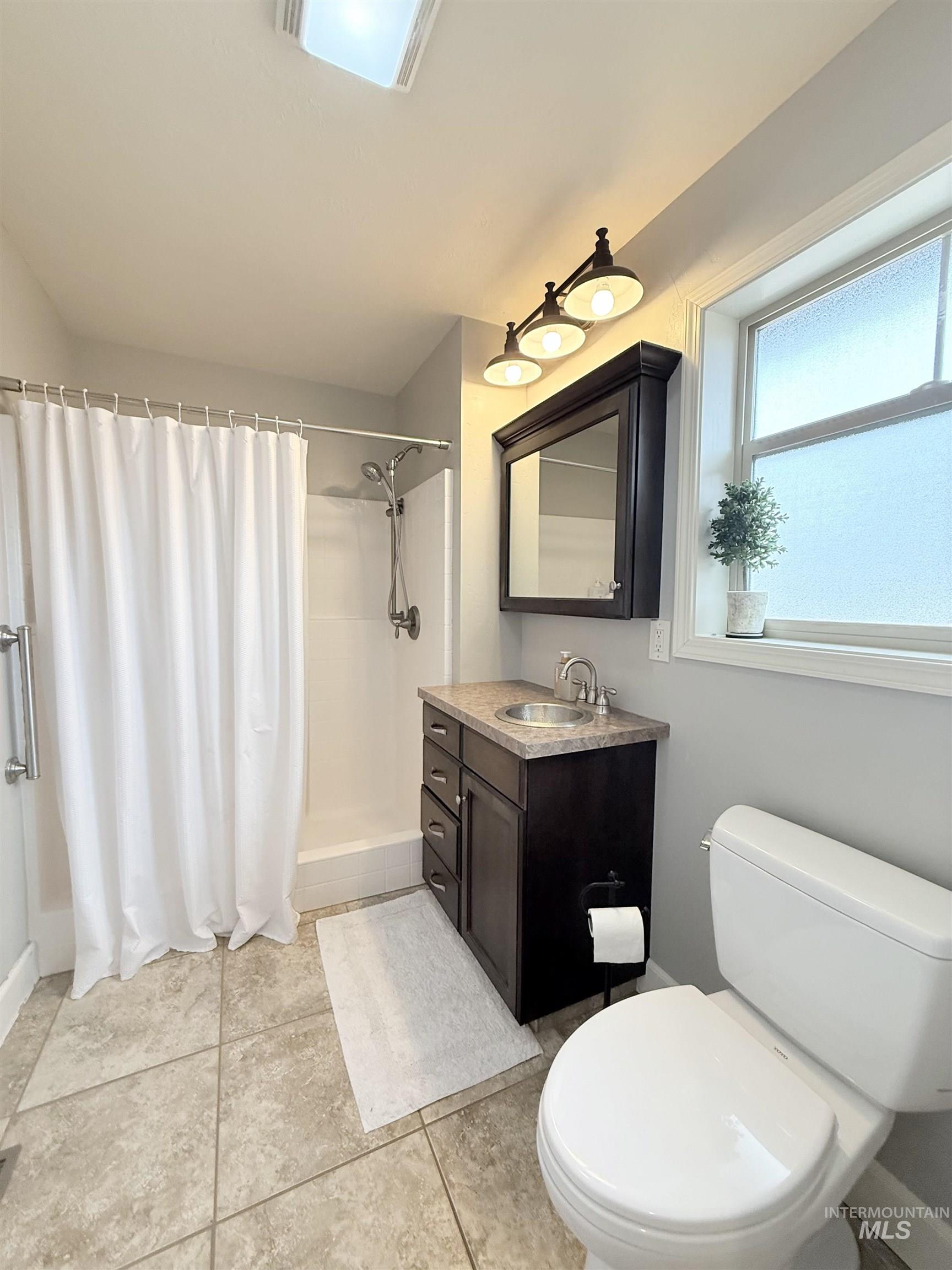 624 20th Street Rupert, ID 83350 - Photo 10 of 31 Bathroom with a stall shower, vanity, and light tile patterned floors