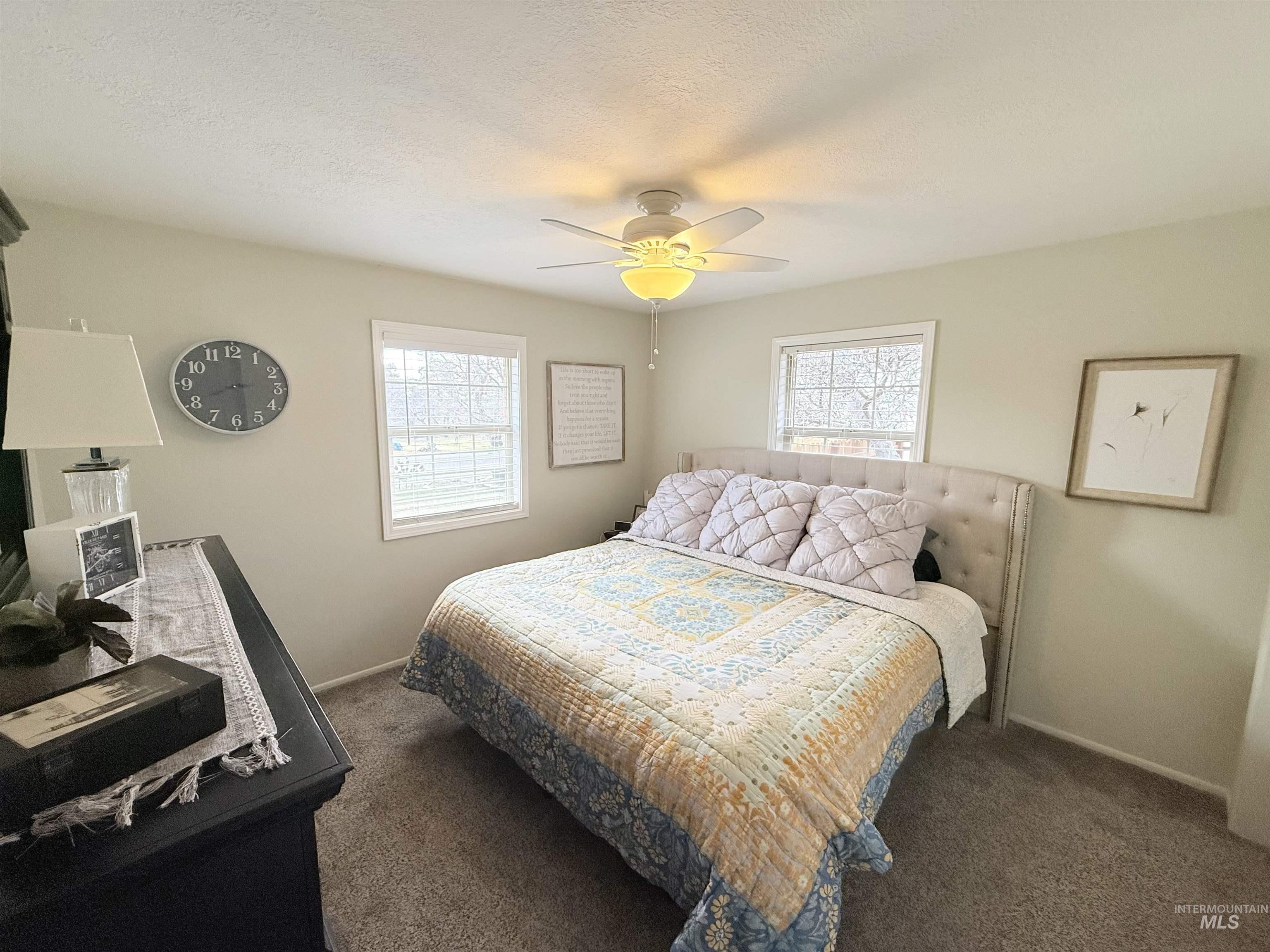 624 20th Street Rupert, ID 83350 - Photo 13 of 31 Bedroom featuring ceiling fan, dark carpet, and a textured ceiling
