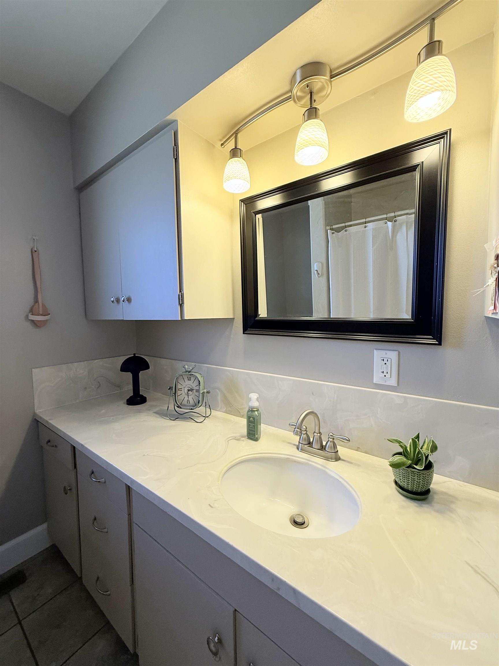 624 20th Street Rupert, ID 83350 - Photo 19 of 31 Full bath with double vanity, a shower with shower curtain, and tile patterned flooring