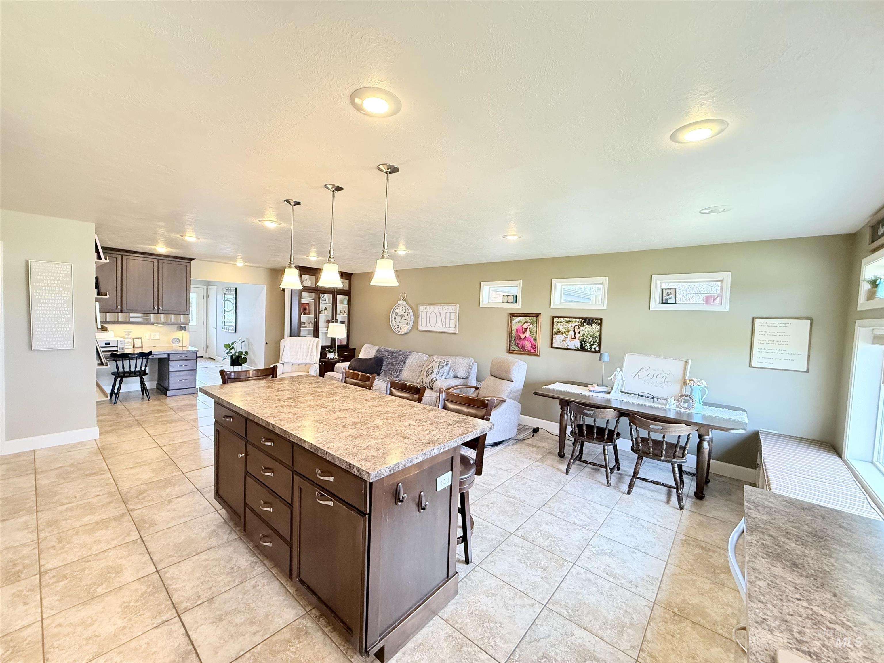 624 20th Street Rupert, ID 83350 - Photo 31 of 31 Kitchen featuring dark wood finish cabinetry, open floor plan, a center island, and light tile patterned floors