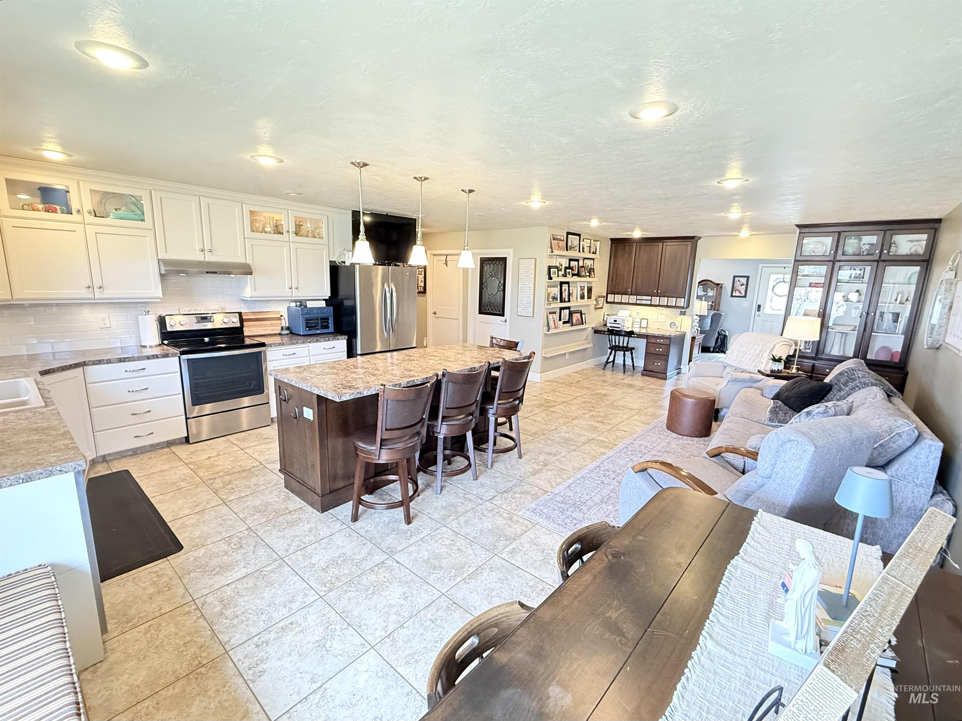 624 20th Street Rupert, ID 83350 - Photo 7 of 31 Kitchen featuring stainless steel appliances, tasteful backsplash, a kitchen island, light tile patterned floors, and dual tone cabinetry