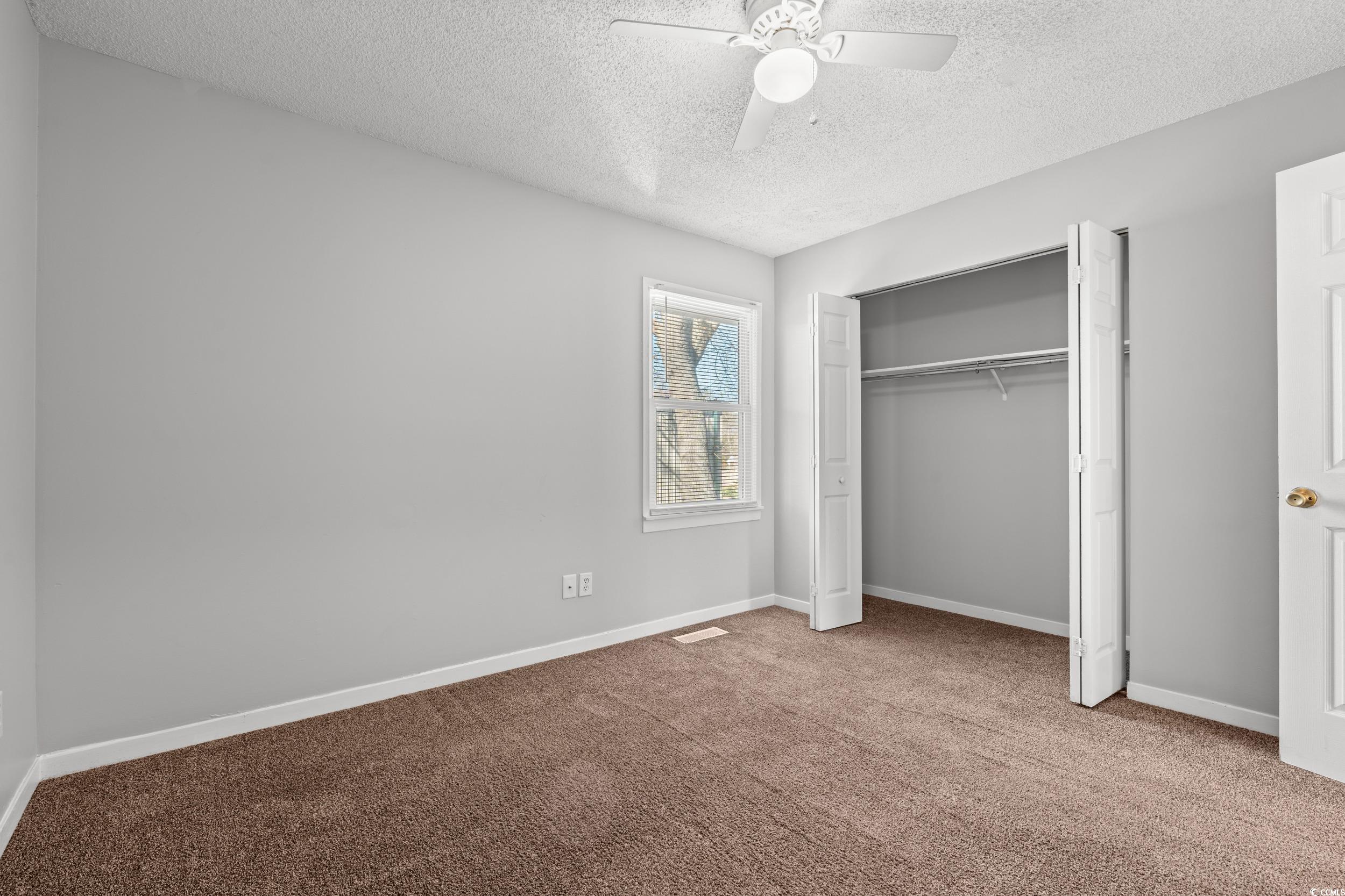 3458 Macklen Road Myrtle Beach, SC 29588 - Photo 13 of 30 Unfurnished bedroom featuring ceiling fan, carpet floors, visible vents, baseboards, and a closet