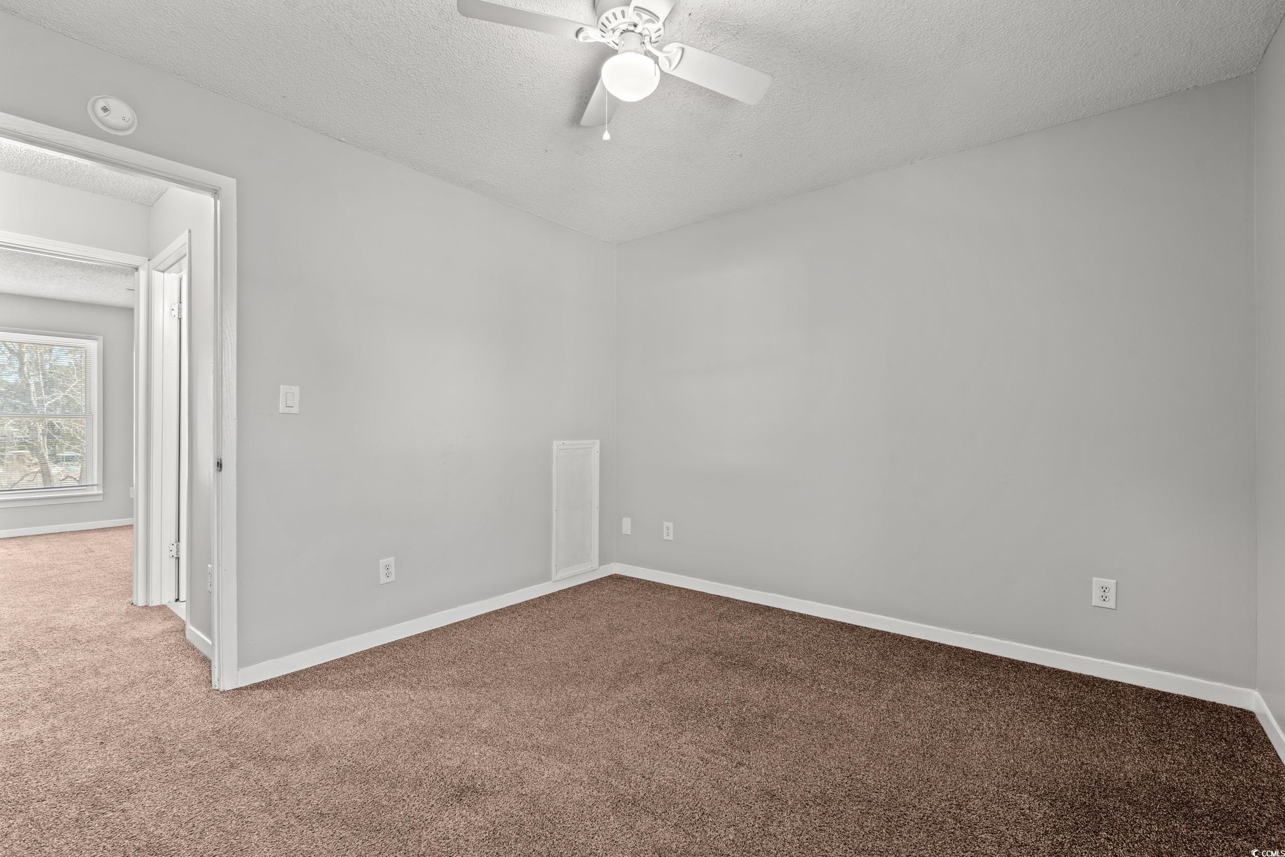 3458 Macklen Road Myrtle Beach, SC 29588 - Photo 18 of 30 Carpeted empty room with ceiling fan, baseboards, and a textured ceiling