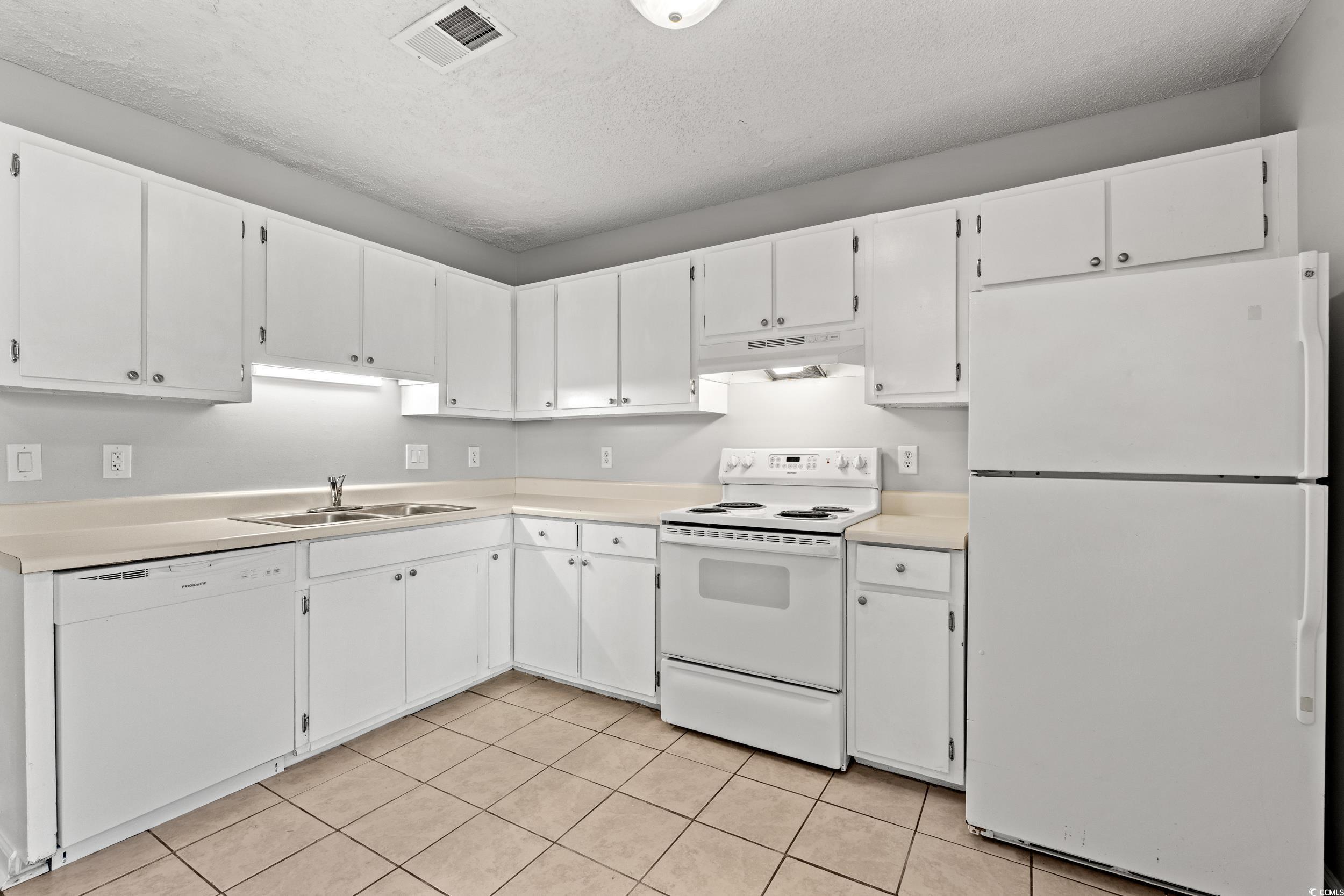 3458 Macklen Road Myrtle Beach, SC 29588 - Photo 10 of 30 Kitchen featuring white appliances, visible vents, under cabinet range hood, and white cabinets