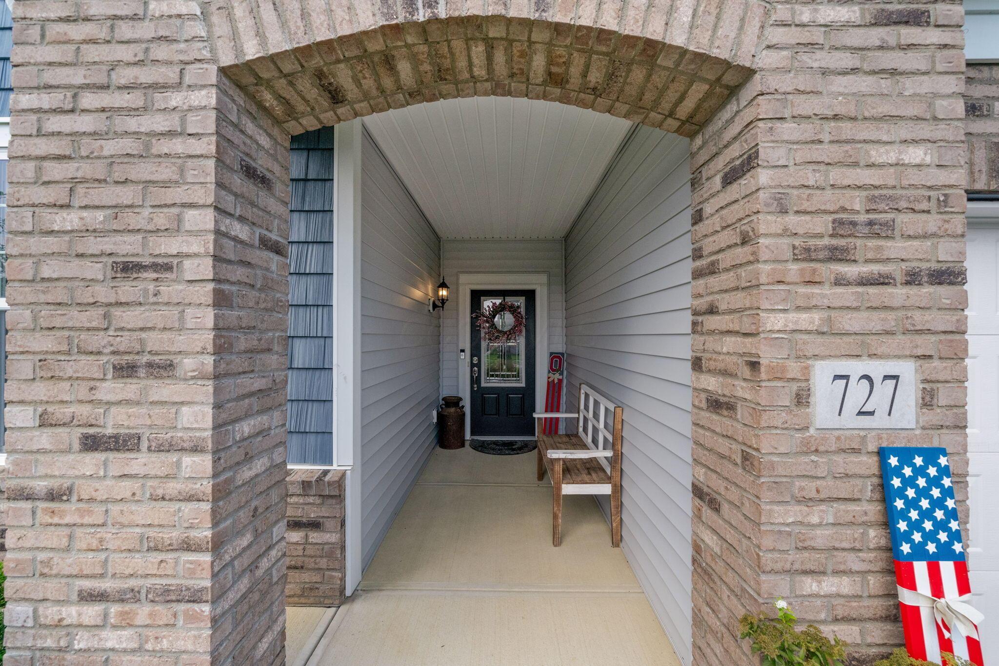 727 Fescue Road Galena, OH 43021 - Photo 4 of 85 The brick arched entry to the covered porch, where there is a wall sconce. The decorative glass front door lets in plenty of light.