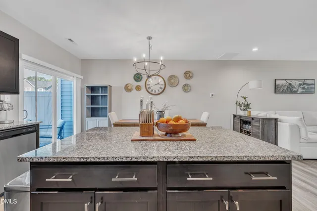 a kitchen with granite countertop kitchen island stainless steel appliances a table and chairs in it
