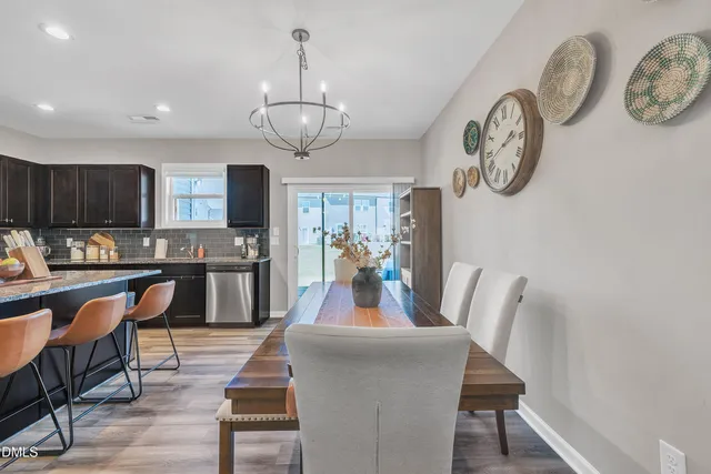 a view of a dining room with furniture a kitchen and chandelier