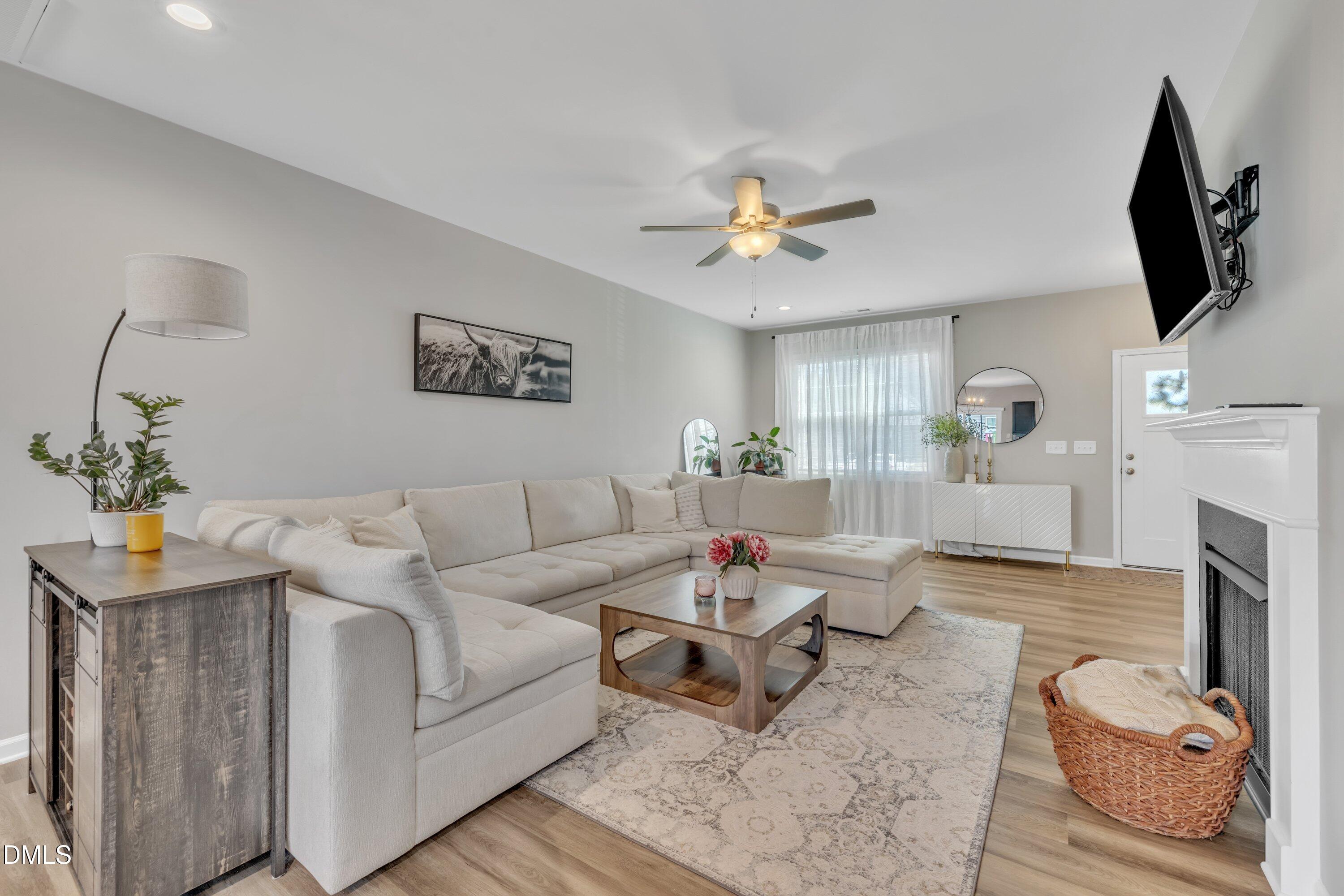 743 Hadstock Path Zebulon, NC 27597 - Photo 16 of 39 a living room with furniture a fireplace and a flat screen tv