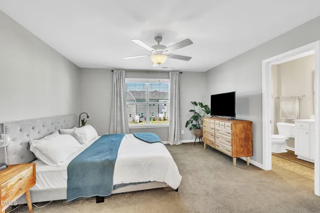 a bedroom with a bed a chandelier and a large window
