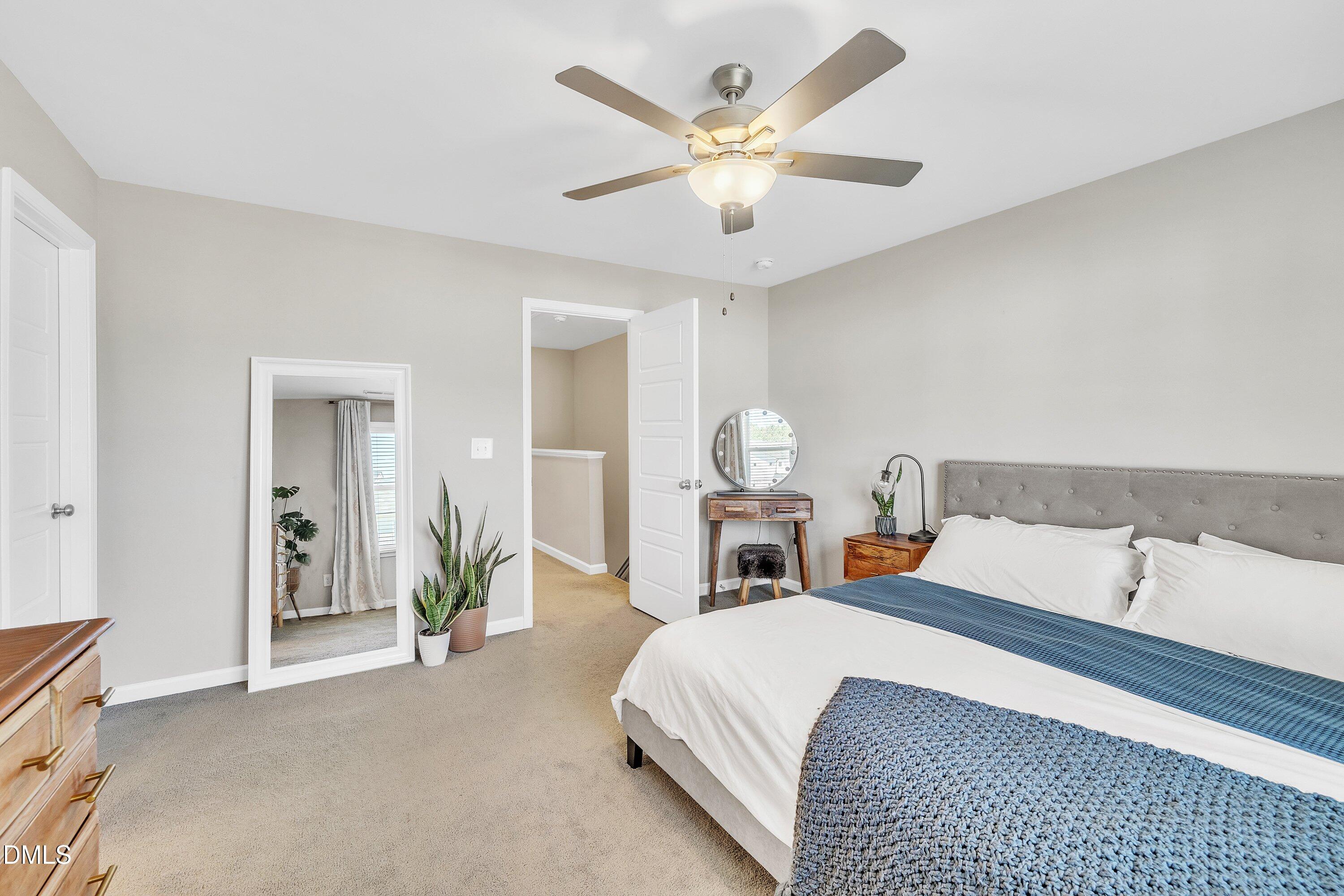 743 Hadstock Path Zebulon, NC 27597 - Photo 25 of 39 a bedroom with a bed and a chandelier