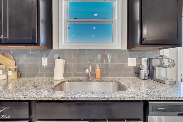 a kitchen with granite countertop a sink and a stove