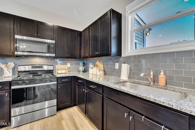 a kitchen with granite countertop cabinets stainless steel appliances and sink