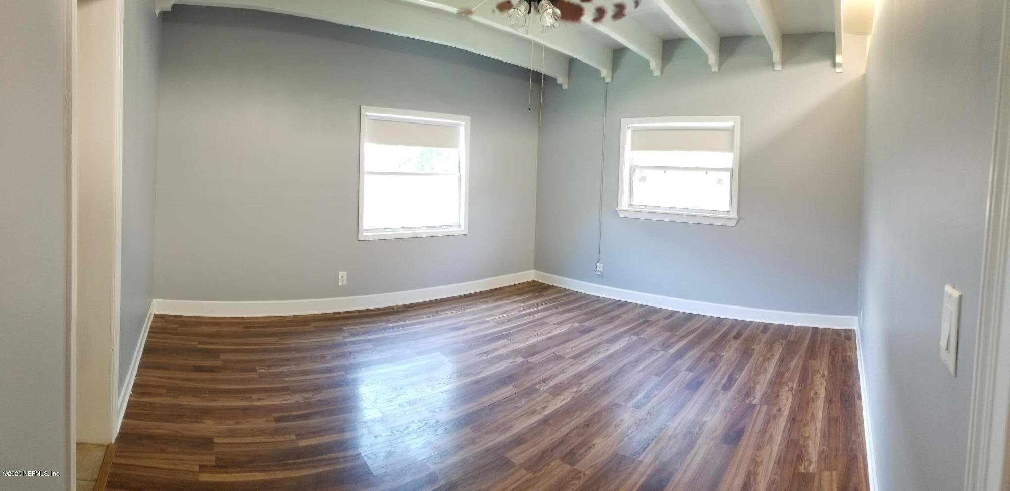 2544 Sam Road Jacksonville, FL 32216 - Photo 8 of 39 an empty room with wooden floor and windows