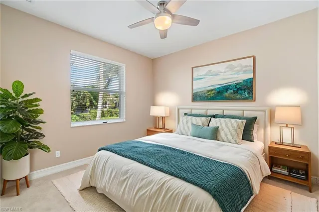 a bedroom with a large bed and a potted plant