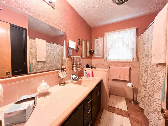 a bathroom with a granite countertop sink and a large mirror