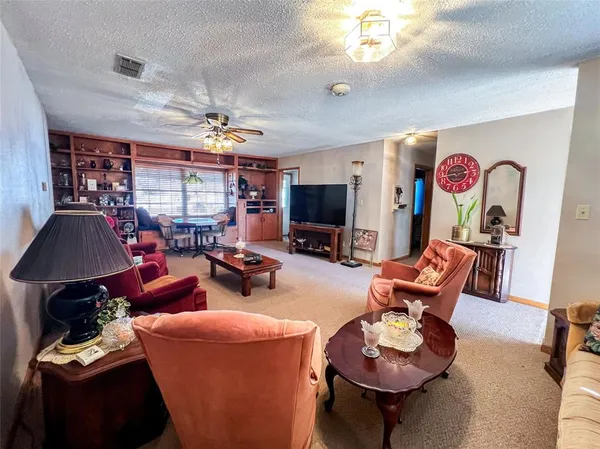 a living room with furniture a chandelier and a flat screen tv