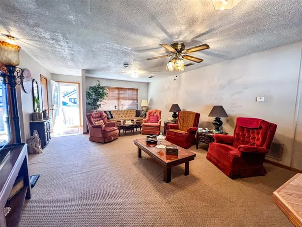 a living room with furniture a ceiling fan and a window