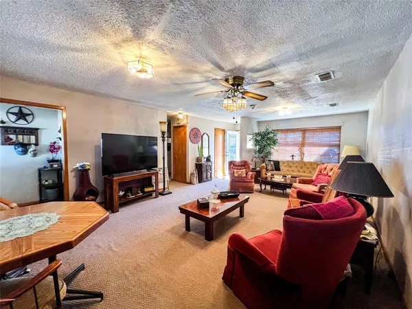a living room with furniture a chandelier and a flat screen tv