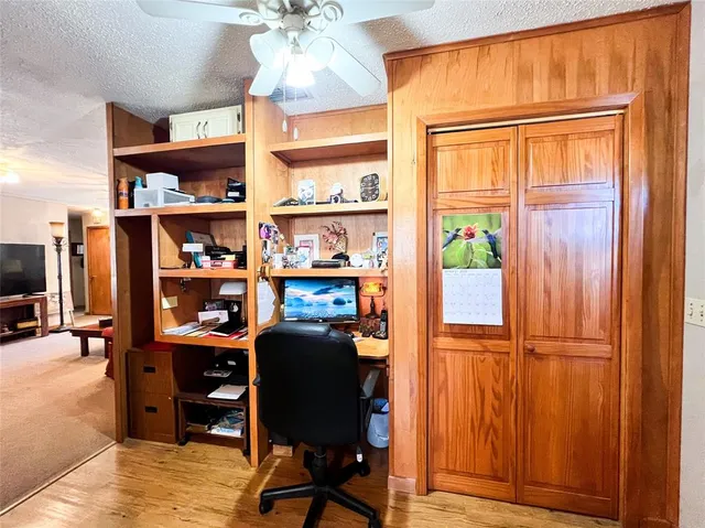a view of a workspace with furniture and a window