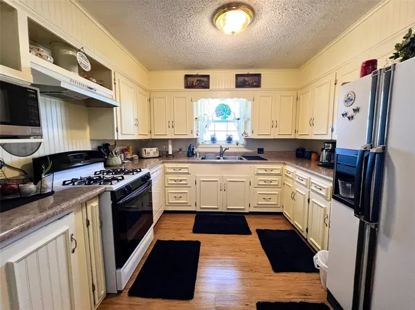 a kitchen with stainless steel appliances a stove a sink and a refrigerator