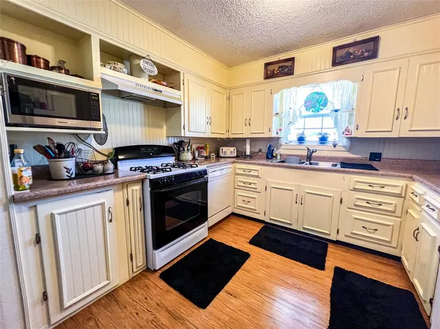 a kitchen with stainless steel appliances a stove a sink and a microwave