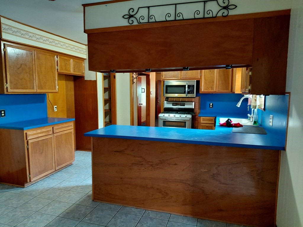 736 Northridge Street Angleton, TX 77515 - Photo 13 of 24 a kitchen with stainless steel appliances granite countertop a stove a sink and a microwave