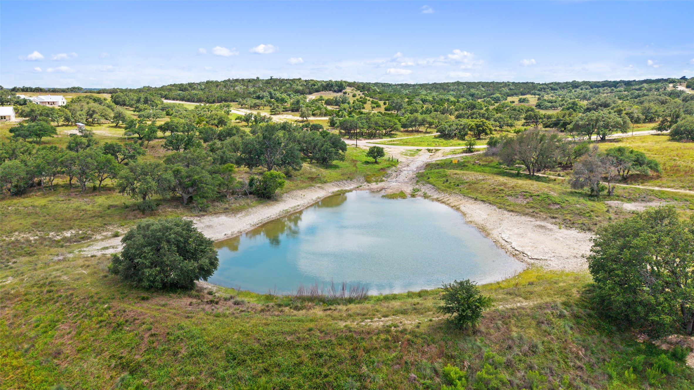 Discover a tranquil pond amidst lush, undeveloped land, offering a peaceful rural escape.