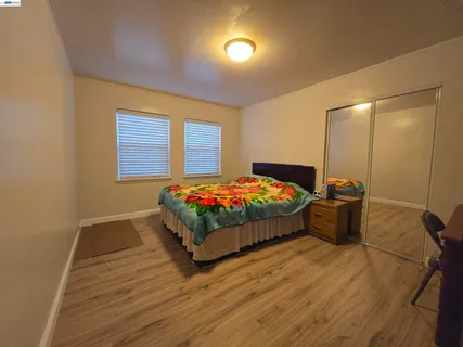 a bedroom with a bed and wooden floor
