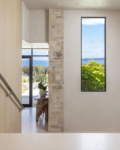 a living room with couches and a potted plant