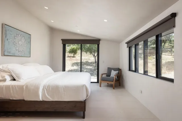 a bedroom with a large bed and a large window