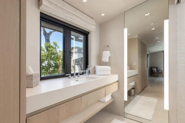 a bathroom with a sink mirror and a bathtub next to a window