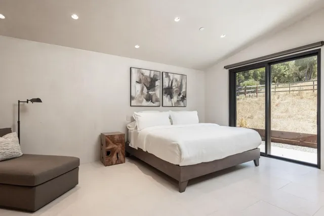 a spacious bedroom with a bed and a large window