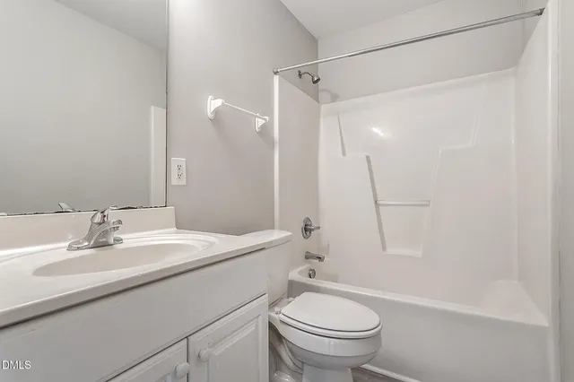 a bathroom with a sink a toilet and a large mirror