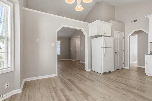 a view of a hallway with wooden floor and closet