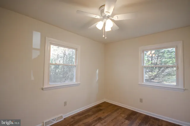 a view of a room with wooden floor and a window