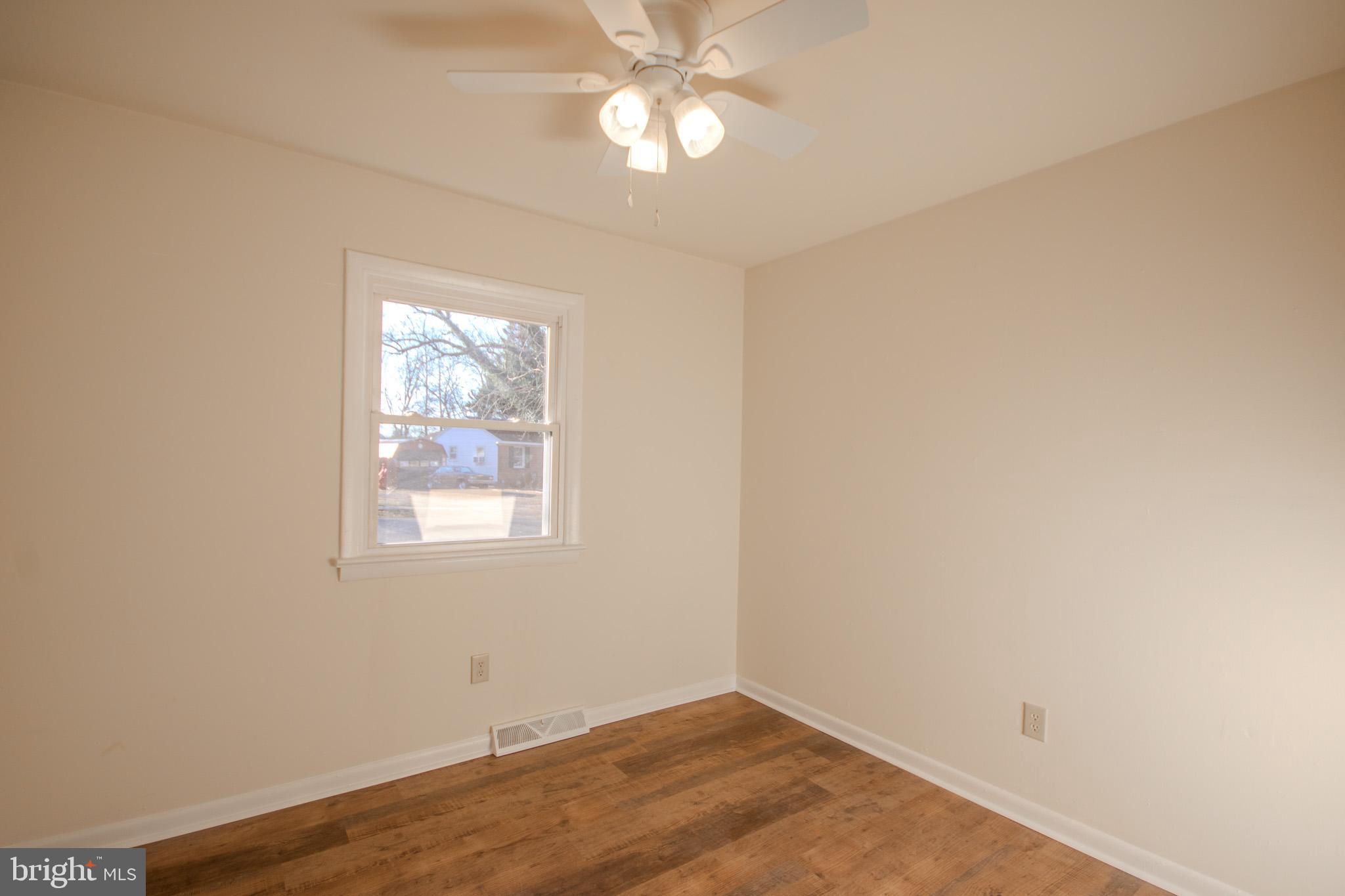 306 Autumn Terrace Salisbury, MD 21804 - Photo 10 of 21 an empty room with a window and wooden floor