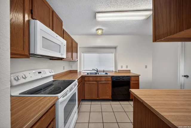 a kitchen with a stove sink and cabinets