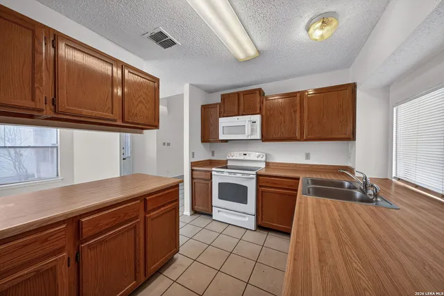 a kitchen with a sink a stove and cabinets