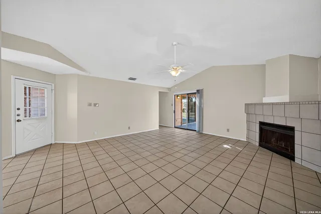 a view of an empty room with window and fire place